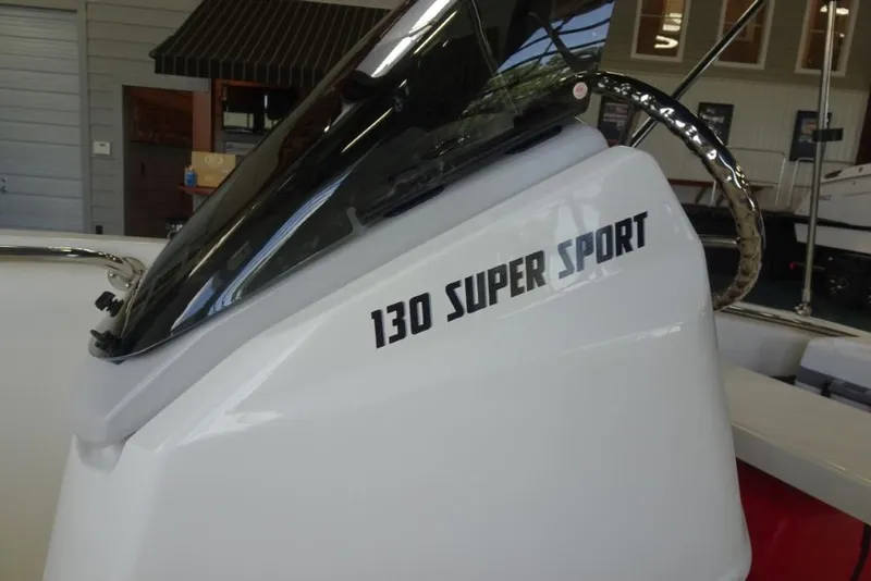Slide: The Image of 2026 Boston Whaler 130 Super Sport boat detail with windshield and logo. - 16