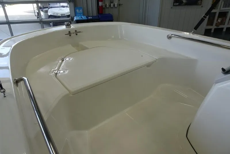 Slide: The Image of 2026 Boston Whaler 130 Super Sport boat interior with storage compartment and stainless steel rails. - 17