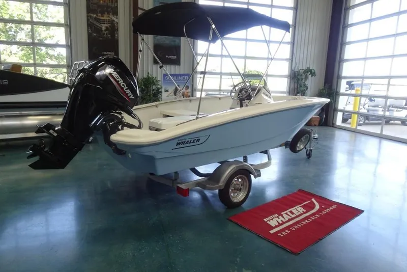 Slide: The Image of 2026 Boston Whaler 130 Super Sport boat with Mercury engine in showroom. - 3