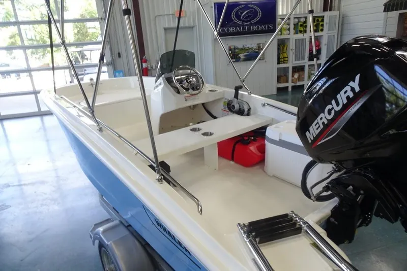 Slide: The Image of 2026 Boston Whaler 130 Super Sport boat with Mercury engine in showroom. - 5