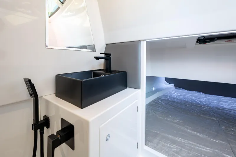 Slide: The Image of Modern bathroom interior on 2023 Vanquish Yachts Sports Line Outboard, featuring sleek black sink. - 14