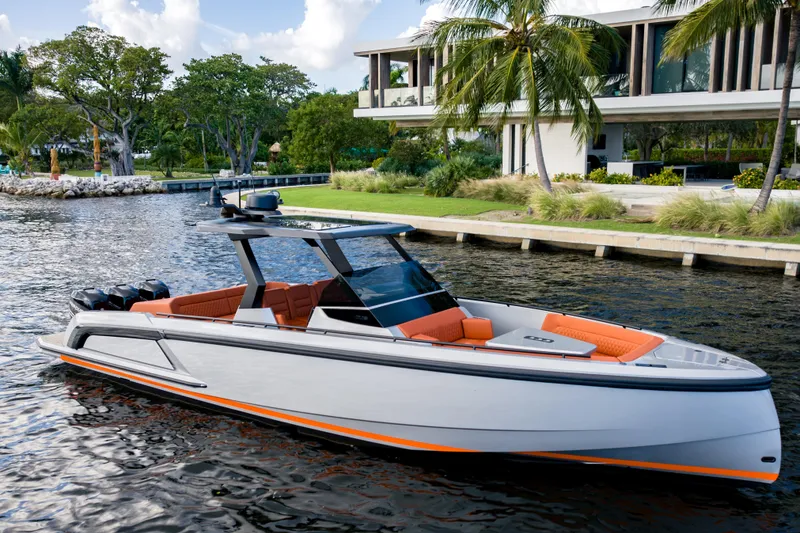 Slide: The Image of 2023 Vanquish Yachts Sports Line Outboard, sleek design, docked by a modern waterfront home. - 2