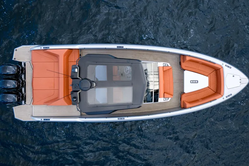 Slide: The Image of 2023 Vanquish Yachts Sports Line Outboard, aerial view, sleek design, orange seating, on water. - 3
