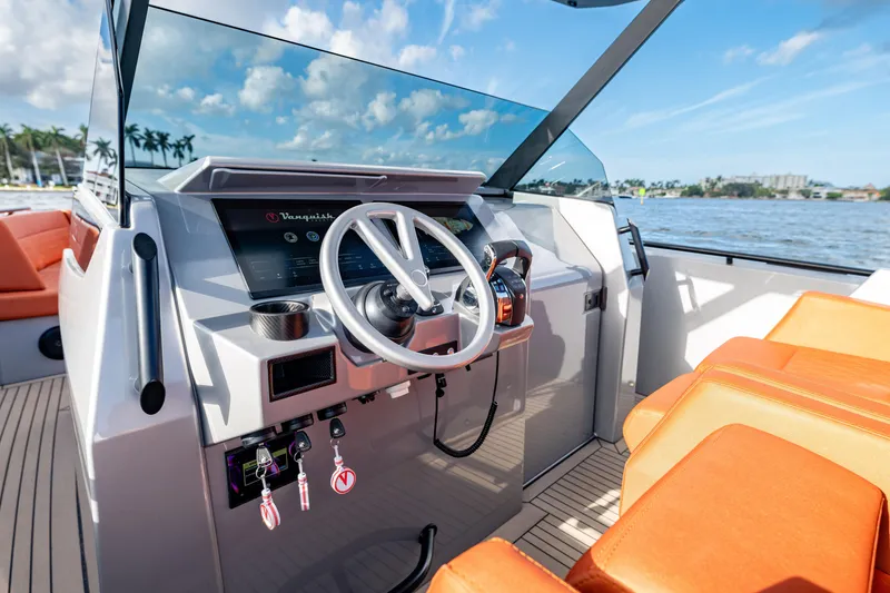 Slide: The Image of 2023 Vanquish Yachts Sports Line Outboard helm with modern controls and orange seating. - 7