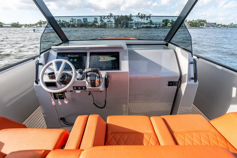 Slide: The Image of 2023 Vanquish Yachts Sports Line Outboard helm with modern controls and orange seating. - 8