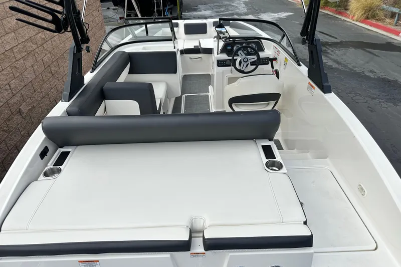 Slide: The Image of 2021 Bayliner DX 2050 boat interior with white and black cushioned seating. - 12