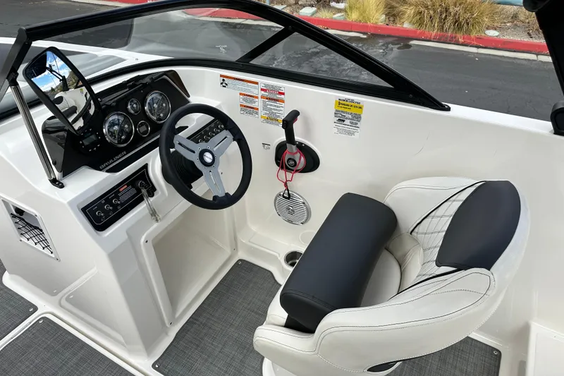 Slide: The Image of 2021 Bayliner DX 2050 boat cockpit with steering wheel and captain's seat. - 17