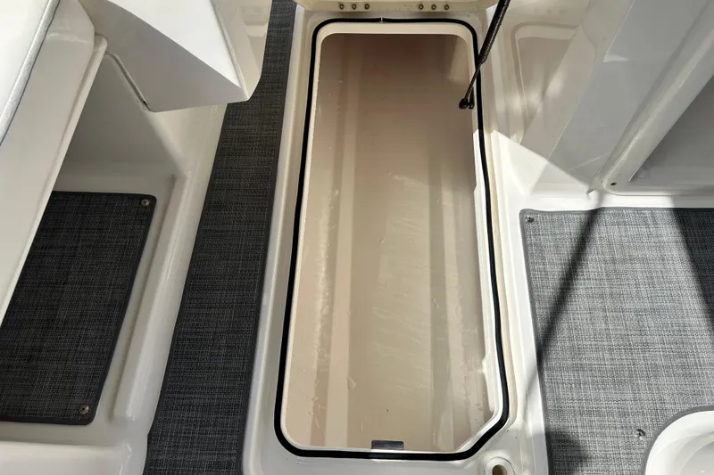 Slide: The Image of 2021 Bayliner DX 2050 boat interior with black canopy, parked outdoors. - 22