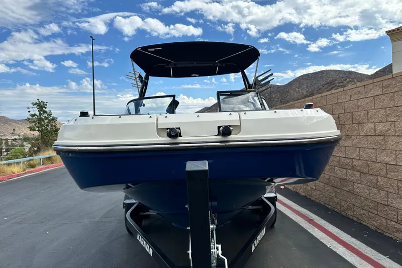 Slide: The Image of 2021 Bayliner DX 2050 boat interior with cushioned seating and cup holders. - 9