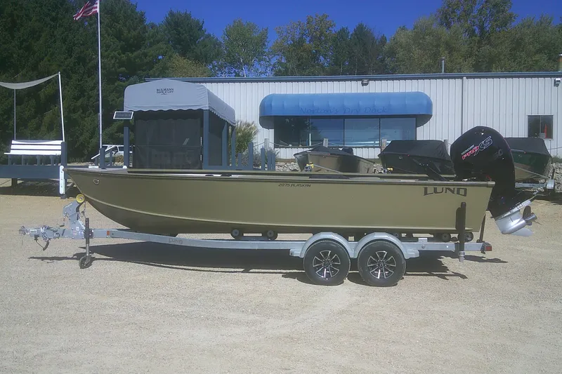 The Image of 2026 Lund 2075 Alaskan Tiller boat on trailer, parked outdoors near dealership. - 0