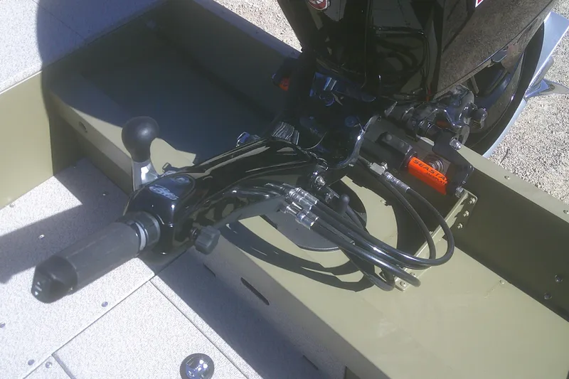 Slide: The Image of 2026 Lund 2075 Alaskan Tiller boat engine controls and steering mechanism. - 10