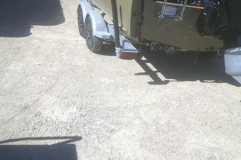 Slide: The Image of 2026 Lund 2075 Alaskan Tiller boat on trailer, parked on gravel surface. - 13