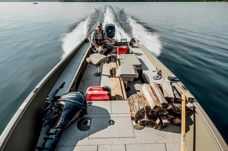 Slide: The Image of Manufacturer Provided Image: 2025 Lund 2075 Alaskan Tiller boat on lake, carrying firewood and equipment. - 17