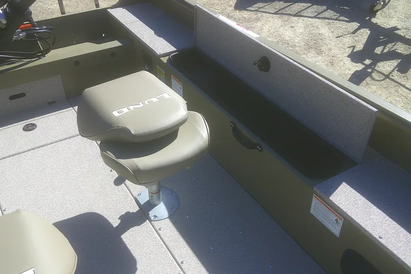 Slide: The Image of 2026 Lund 2075 Alaskan Tiller boat interior with cushioned seat and storage compartments. - 5