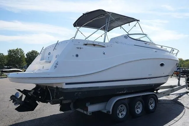The Image of 2007 Rinker 280 Fiesta Vee boat on trailer, white exterior, parked outdoors. - 1