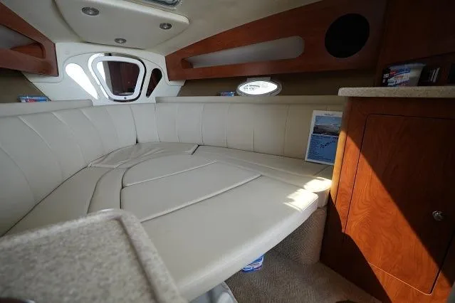 Slide: The Image of 2007 Rinker 280 Fiesta Vee cabin interior with beige seating and wooden accents. - 18