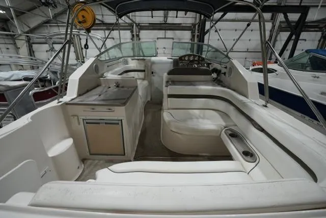 Slide: The Image of 2007 Rinker Fiesta Vee 280 boat interior with seating and helm in a storage facility. - 20