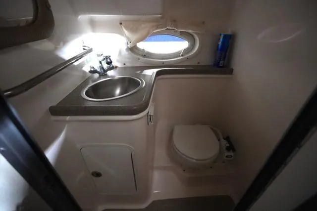 Slide: The Image of 2007 Rinker Fiesta Vee 280 boat bathroom with sink, toilet, and porthole window. - 29