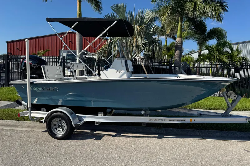 Slide: The Image of 2019 Cape Craft 180 boat on trailer, parked outdoors with palm trees in background. - 30