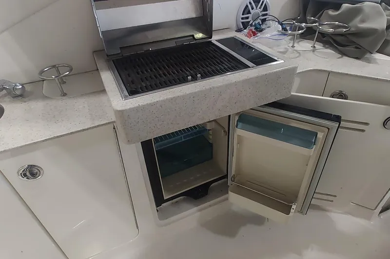 Slide: The Image of 2011 Sea Ray 330 Sundancer boat kitchen with grill and open fridge. - 10