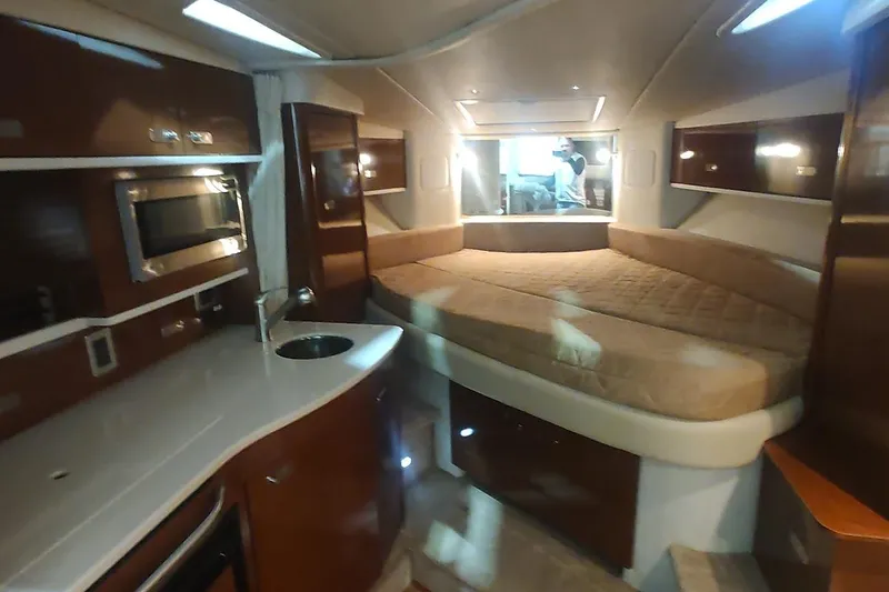 Slide: The Image of Interior of 2011 Sea Ray 330 Sundancer yacht with kitchenette and cozy sleeping area. - 16