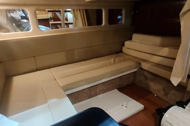 Slide: The Image of 2011 Sea Ray 330 Sundancer cabin interior with beige seating and windows. - 18