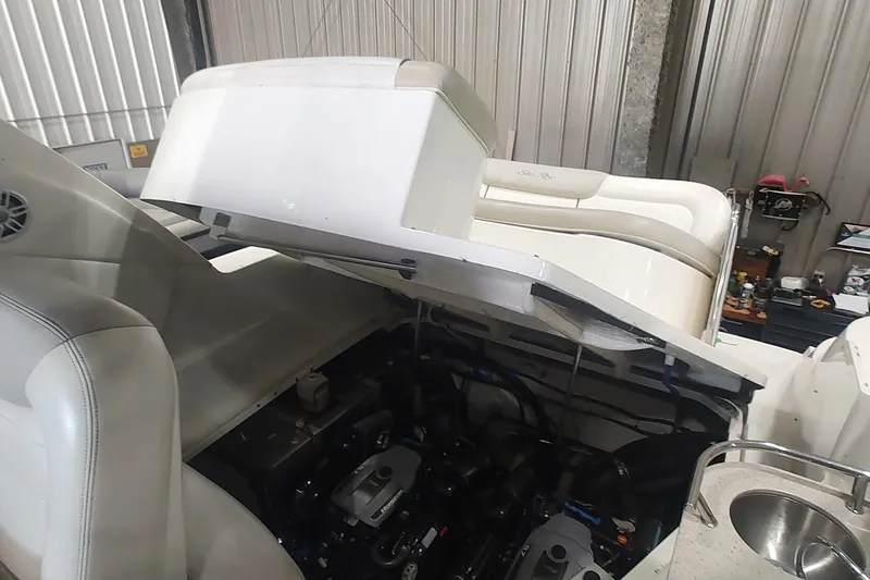 Slide: The Image of 2011 Sea Ray 330 Sundancer engine compartment open in a garage setting. - 23