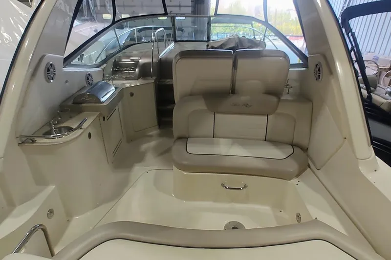 Slide: The Image of 2011 Sea Ray 330 Sundancer interior with seating, kitchenette, and helm in a spacious cabin. - 5