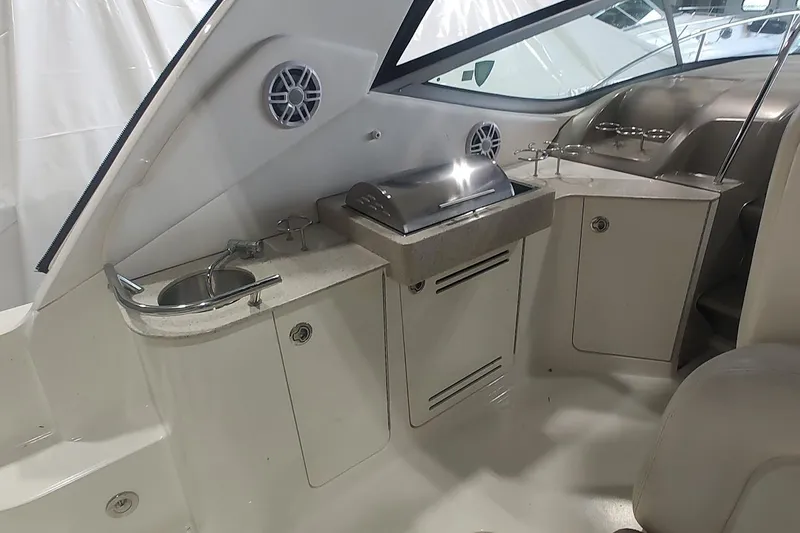 Slide: The Image of 2011 Sea Ray 330 Sundancer interior with sink, grill, and storage cabinets. - 8