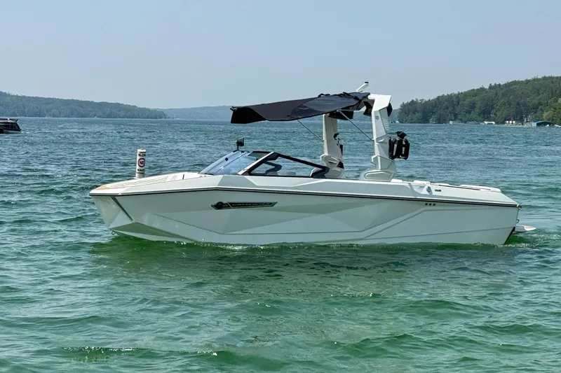 Slide: The Image of 2025 Nautique Super Air Nautique G23 boat on a serene lake. - 1