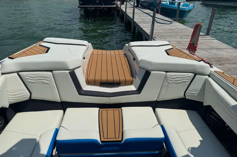 Slide: The Image of 2025 Nautique Super Air Nautique G23 boat interior with white seating and wooden accents. - 3