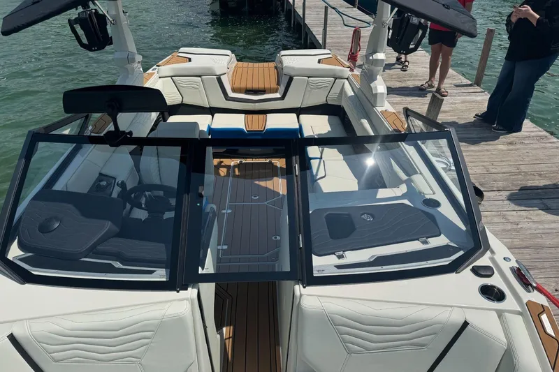 Slide: The Image of 2025 Nautique Super Air Nautique G23 boat interior at dock, featuring sleek design and seating. - 4
