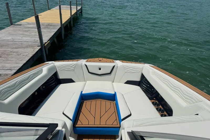Slide: The Image of 2025 Nautique Super Air Nautique G23 boat interior near wooden dock. - 8