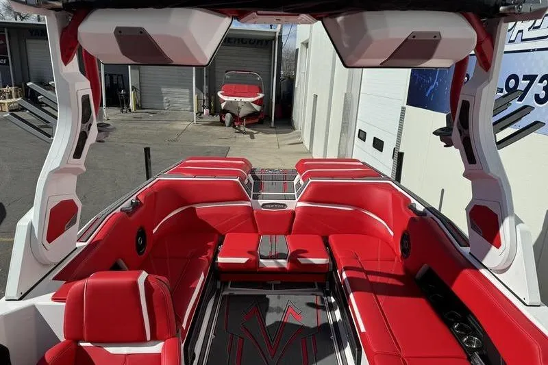 Slide: The Image of 2024 Supra SL 575 boat interior with red and white seating, docked in a marina. - 10