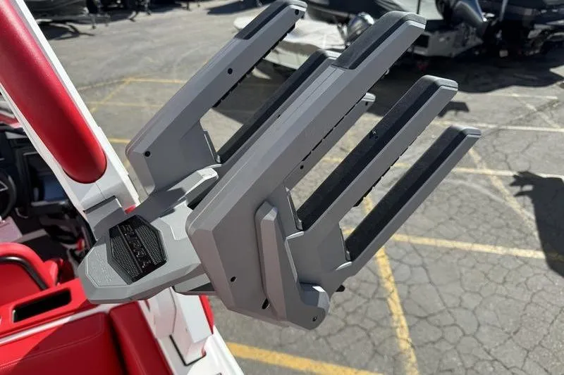 Slide: The Image of 2024 Supra SL 575 boat accessory with red and gray detailing in a parking lot. - 11