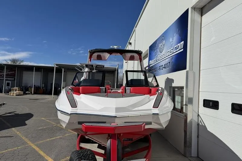 Slide: The Image of 2024 Supra SL 575 boat with red accents parked outside a building. - 4