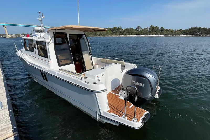 Slide: The Image of 2023 Ranger Tugs R-25 boat with Yamaha engine docked on calm water. - 12