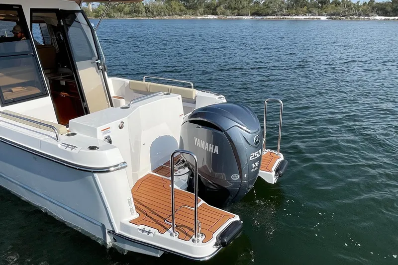 Slide: The Image of 2023 Ranger Tugs R-25 with Yamaha 250 V6 engine on calm water. - 13