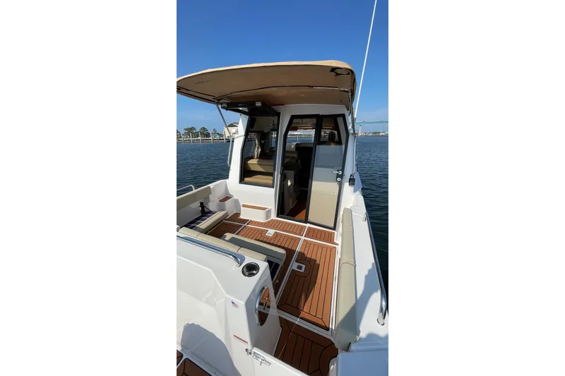 Slide: The Image of 2023 Ranger Tugs R-25 boat with teak deck and canopy, docked by the water. - 17