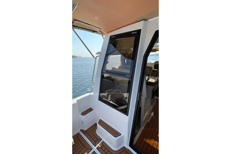 Slide: The Image of 2023 Ranger Tugs R-25 boat interior with wooden deck and window view. - 26