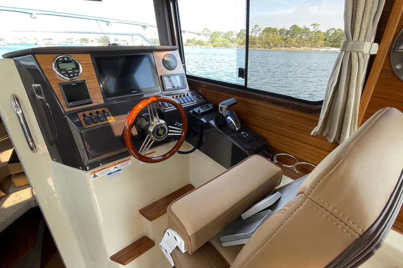 Slide: The Image of 2023 Ranger Tugs R-25 helm with wood accents and modern navigation equipment. - 28
