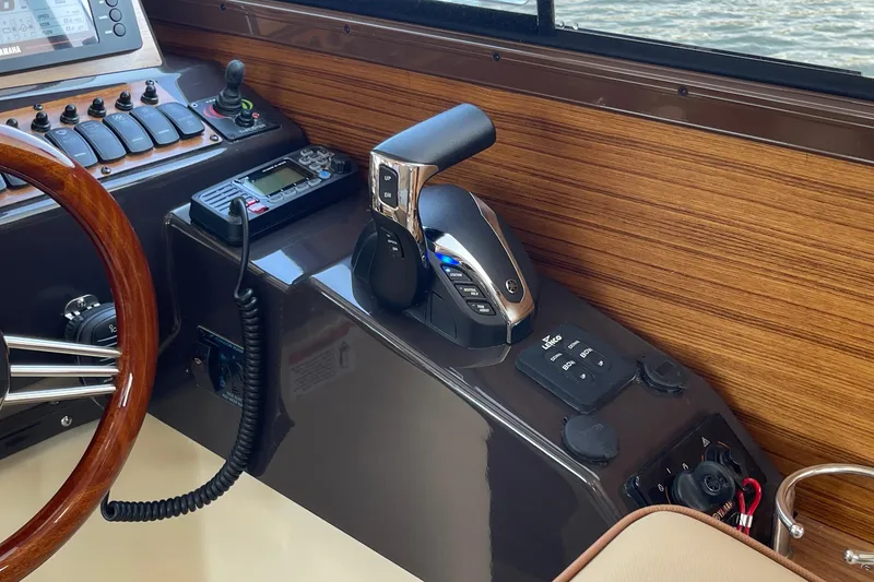 Slide: The Image of 2023 Ranger Tugs R-25 helm with controls and wooden steering wheel. - 32