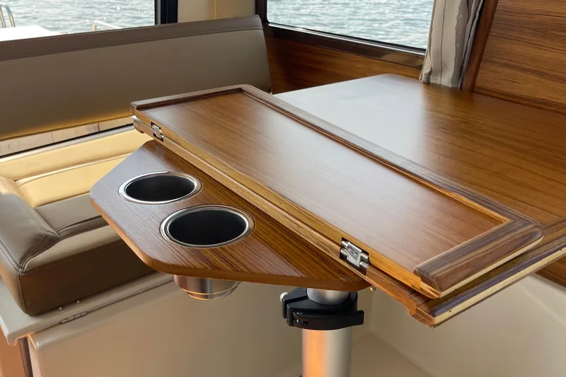 Slide: The Image of 2023 Ranger Tugs R-25 interior with wooden table and cup holders. - 38