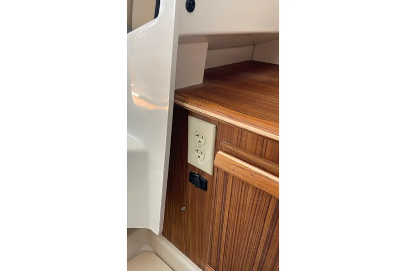 Slide: The Image of 2023 Ranger Tugs R-25 interior with wood finish and electrical outlet. - 39