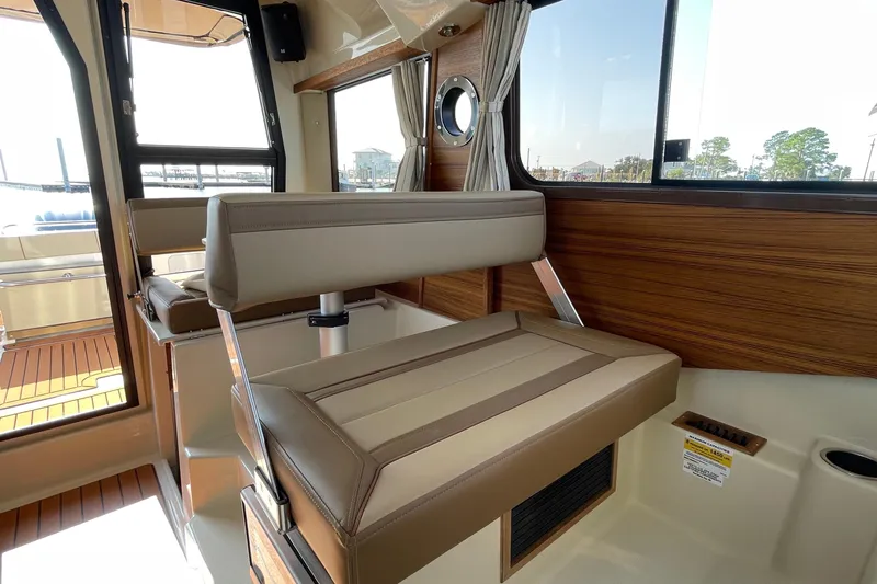 Slide: The Image of Interior of 2023 Ranger Tugs R-25 boat, featuring stylish seating and wood paneling. - 40
