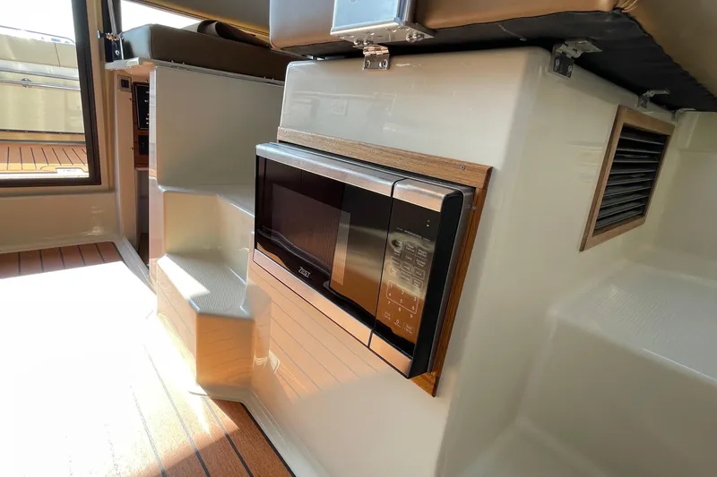 Slide: The Image of 2023 Ranger Tugs R-25 interior with built-in microwave and wooden flooring. - 41