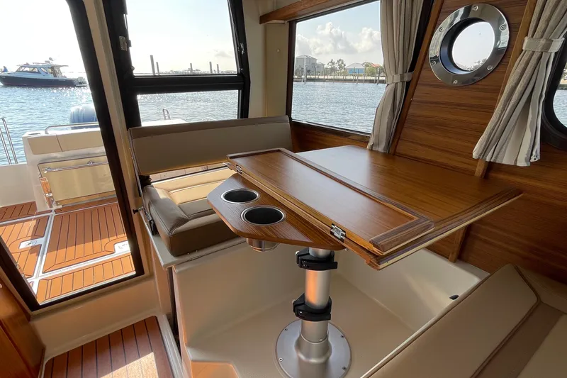 Slide: The Image of Interior of 2023 Ranger Tugs R-25 with wooden table and waterfront view. - 42