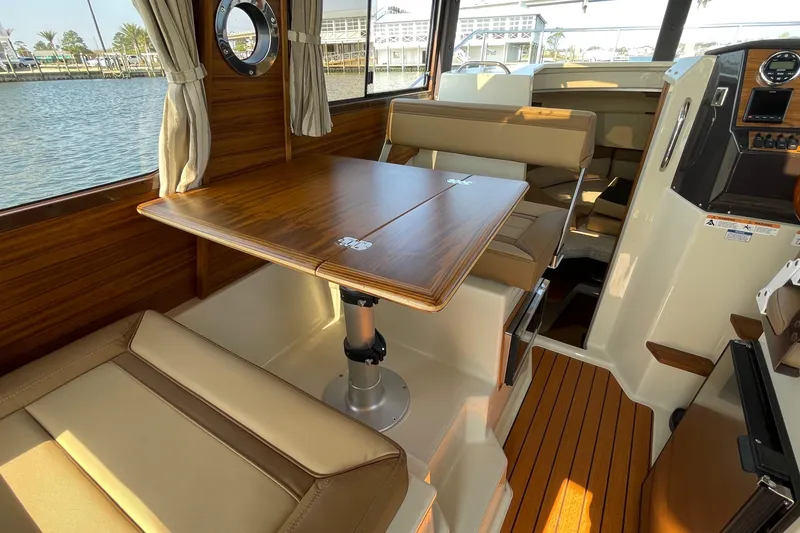 Slide: The Image of Interior of 2023 Ranger Tugs R-25 boat with wood table and seating. - 45