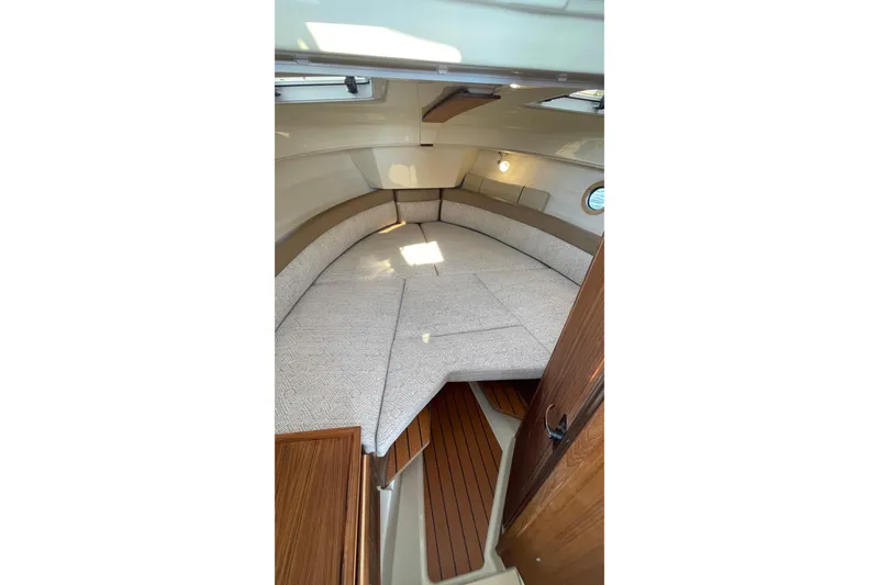 Slide: The Image of 2023 Ranger Tugs R-25 cabin interior with cozy bed and wooden accents. - 47