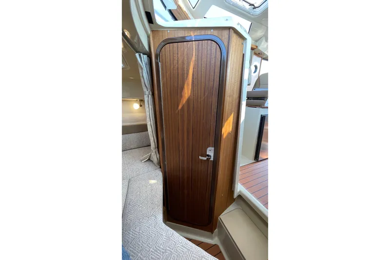 Slide: The Image of 2023 Ranger Tugs R-25 interior with wooden door and cozy cabin space. - 49